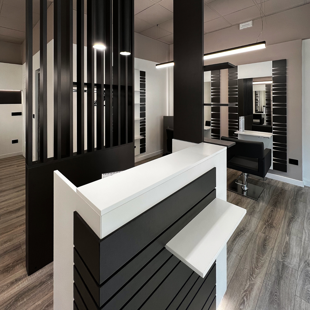 Immagine della reception con bancone bianco a strisce in legno nere